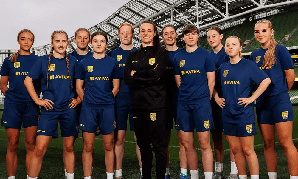 Group of girl football players with Irish football star Áine O’Gorman sporting Football Association of Ireland kits with the Aviva logo.