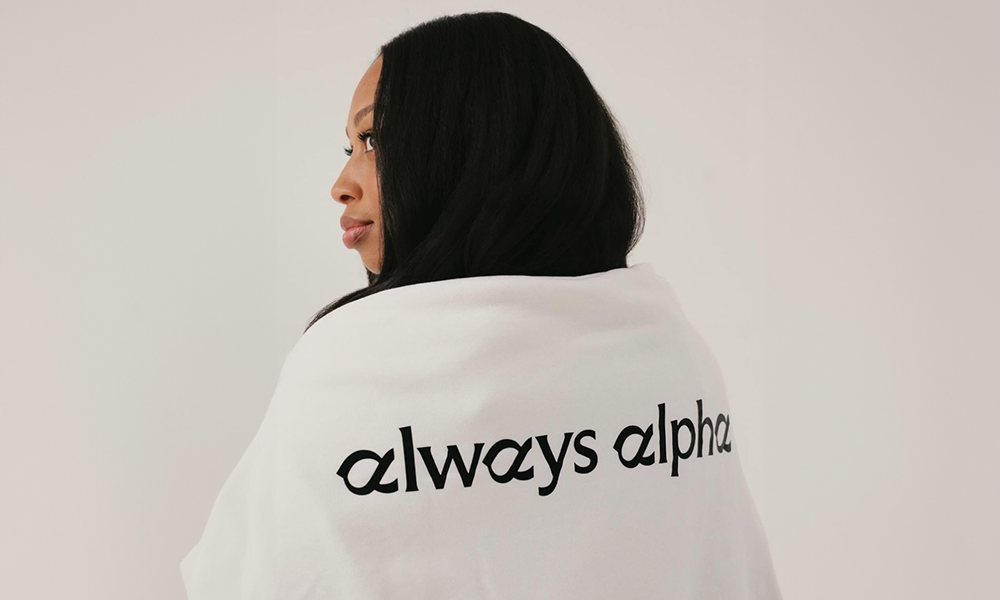 Allyson Felix back turned wearing a sweater with Always Alpha on the back