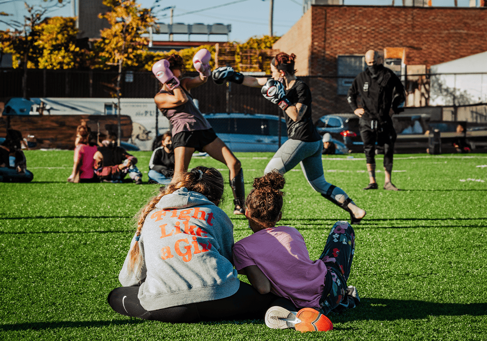 Two Box United participants boxing - jumper reads Fight Like a Girl 